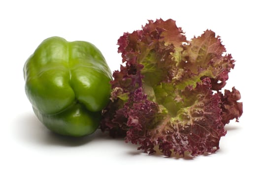 Green pepper and salad leaves on a white background.