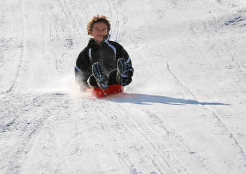 scared boy sledding fast down the hill with snow background