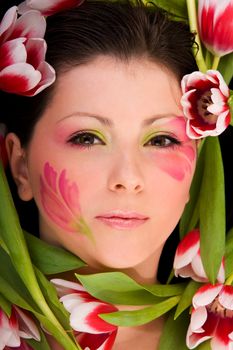 Closeup image of young woman face framed with tulips