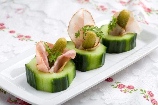 Small snack with cucumber, gurkin and ham rolled into one