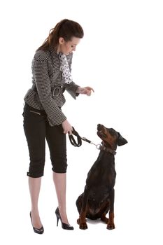 Pretty young woman directing her doberman pincher