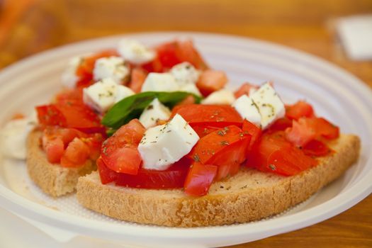 Bruschetta with tomatoes, mozarella and basil served in a cafe