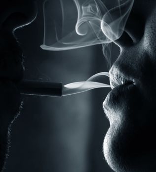 Two silhouettes of smoking people close-up