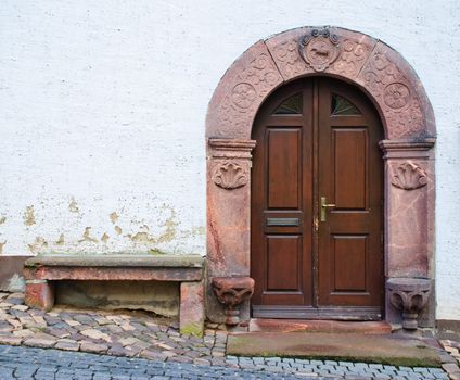 Entrance grey wooden door in a stone list