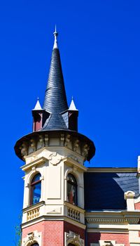 Wing peaked with two windows in the dark blue sky in an old city