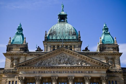 Domes of a building of court of a city of Leipzig against the blue summer sky