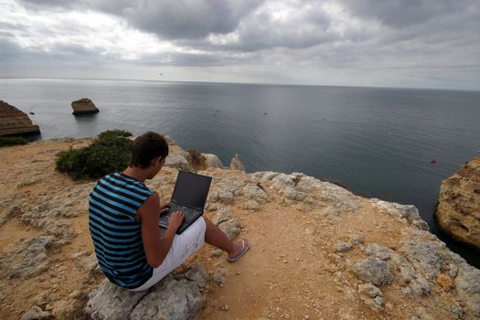 man working with laptop on the coast