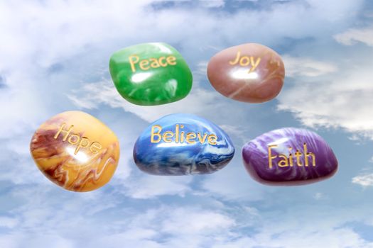 five stones inscribed hope joy peace faith and believe in the heavens