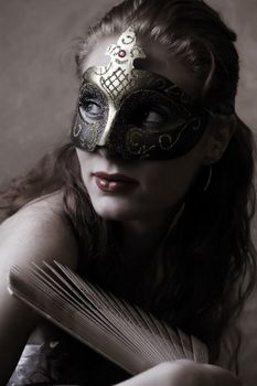 mysterious woman in mask and with fan