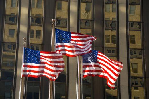 3 american flags against building