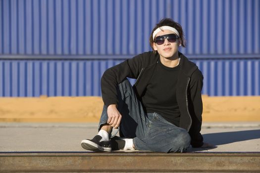 Teenage boy wearing glasses in front of train