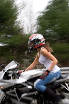Abstract blur of a pretty girl driving a motorcycle at highway speeds.