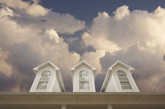 House Roof and Windows Against a Cloudy Sky