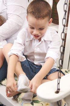 Adorable Young Boy Getting Dressed Putting His Socks On