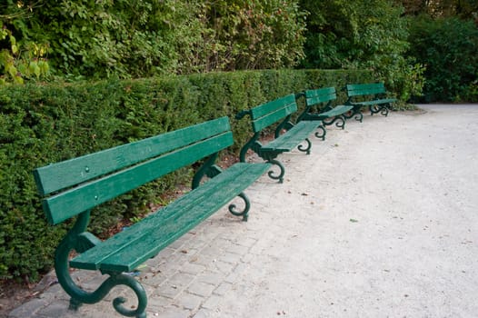 Row of green benches in Bruges park