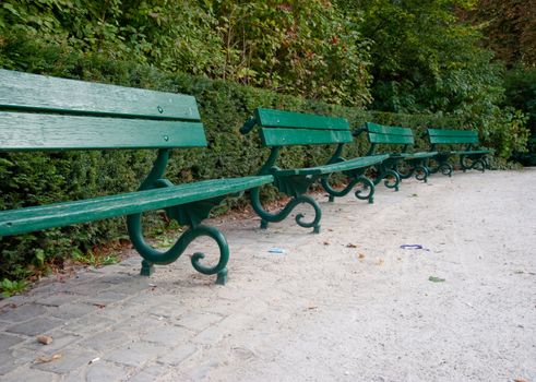 Row of green benches in Bruges park