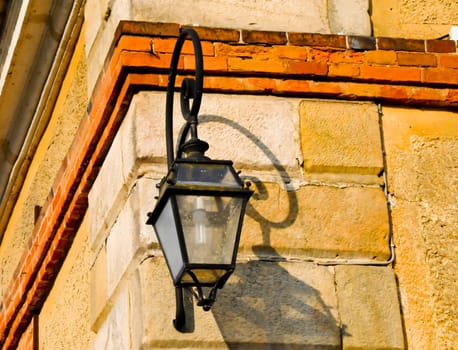 Lamp on sunlit building