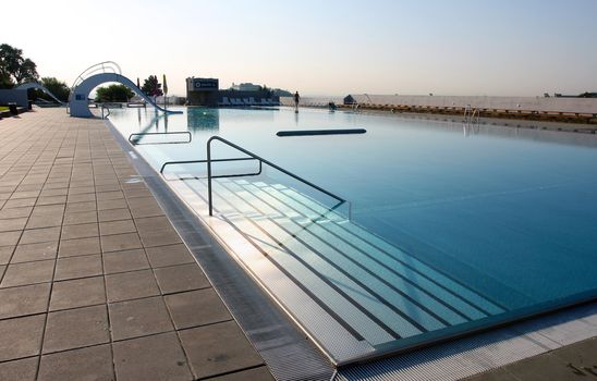 Dispeopled bath pool with white slide