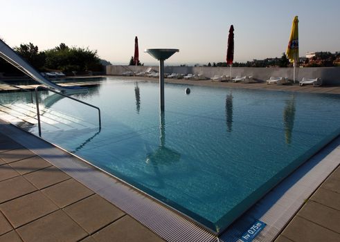 Dispeopled bath pool with white slide