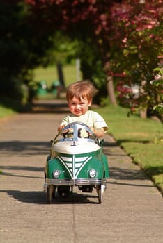 boy driving pedal car