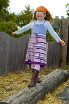 girl balancing on log