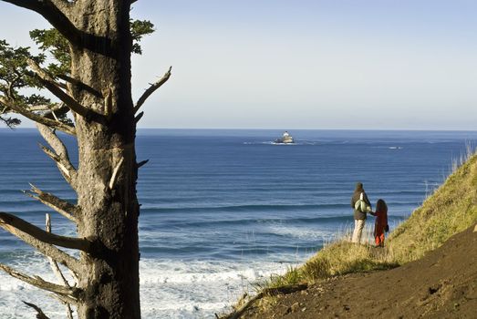 mother and daughter on coast trail at Ecola State Park, and the Tilamook Light House, Oregon Coast, usa