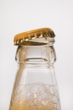 Opening the top of a beer bottle showing the foam starting to rise.