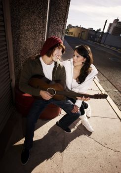 Hispanic musician and Latina Girlfriend downtown at sundown