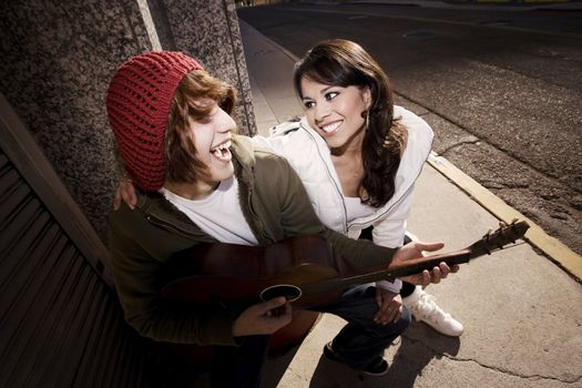 Hispanic musician and Latina Girlfriend downtown at sundown