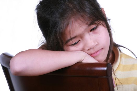 Sad girl sitting on chair, part Asian-Scandinavian descent