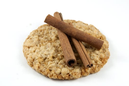An oatmeal cookie with cinnamon sticks on top.