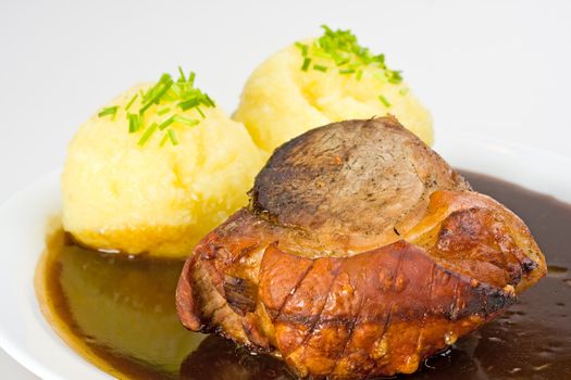 traditional bavarian roast pork with beer sauce and dumplings