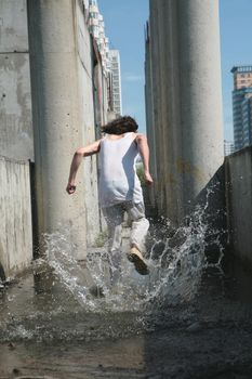 man in white cloth runs away on water amongst concrete construction