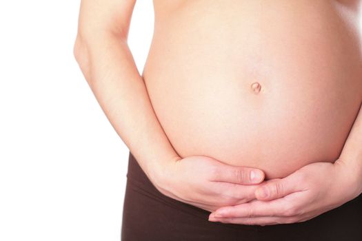 close-up, belly and hands of the pregnant woman on white background