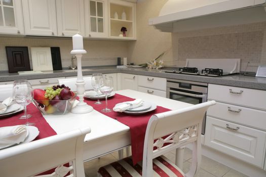 modern kitchen with white furniture in classical style and with served table