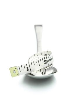 Conceptual diet image of ameasuring tape on a spoon isolated against a white background