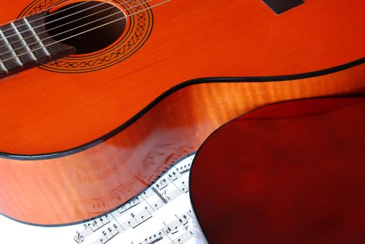 Shining acoustical guitar over music book with notes