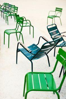 Green metallic chairs in the city park. Photo with tilt-shift lens