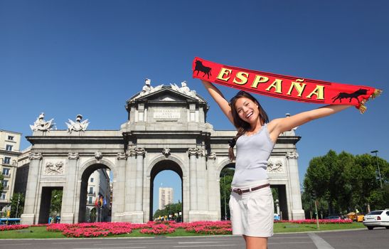 Spain - Madrid Tourist holding Espana banner in front of Puerta de Alaca on Plaza de la Independencia - famous tourist attraction.