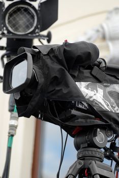 Profesional TV camera with all weather cover awaiting action.