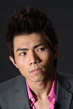 Modern young businessman look copyspace, closeup portrait of Asian guy in dark.