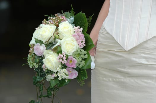 Bride is holding her wedding bouquet.