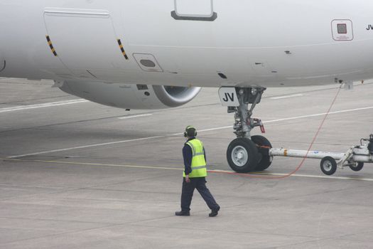 Aircraft departure controller connected to the cockpit and guiding the aircraft out during initial pushback.