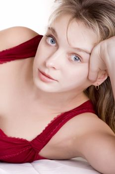 Beautiful smiling woman in red on bed at bedroom portret
