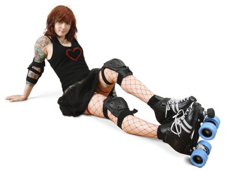 Photograph of a roller derby girl posing on the floor with her equipment.