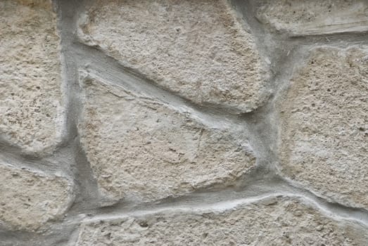 a detail of a grey, old, weathered stonewall