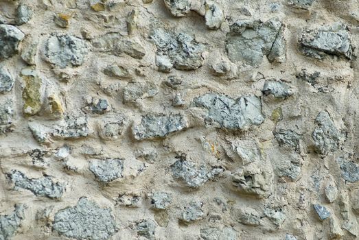 a detail of a grey, old, weathered stonewall