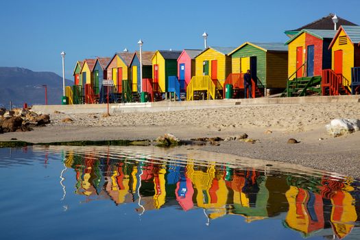 Brightly painted wooden bathing huts at St James Beach, near Cape Town, South Africa.