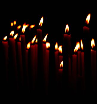 candle flames in church against black background