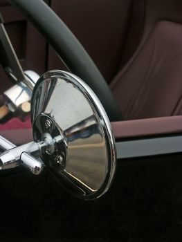 Stainless steel custom drivers mirror on the door of a hotrod car